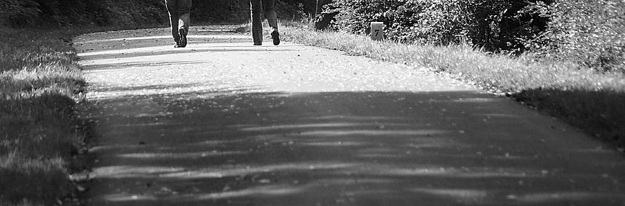 grayscale photo of two person walking on pathway thumbnail