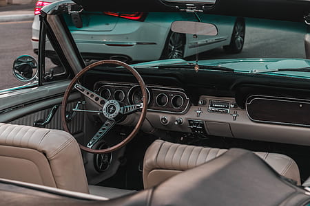 brown and gray Ford Mustang convertible interior near white vehicle on road thumbnail