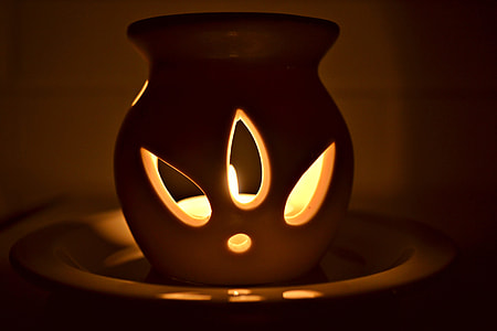 lit candle in white ceramic wax candle warmer thumbnail