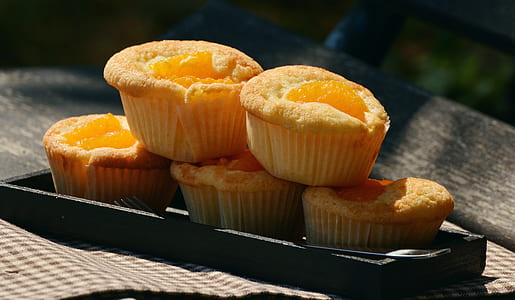 five baked muffins on black plate thumbnail