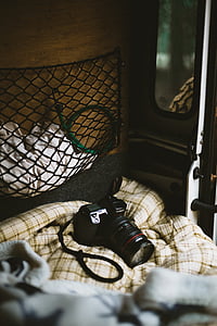 Canon DSLR camera on plaid bed comforter thumbnail