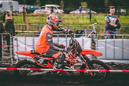person riding on motorcycle near man standin behind gray steel fence thumbnail