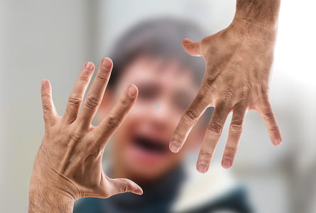 tilt shift lens photo of hands holding boy's face thumbnail