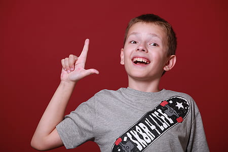 boy wearing gray shirt doing hand gesture thumbnail