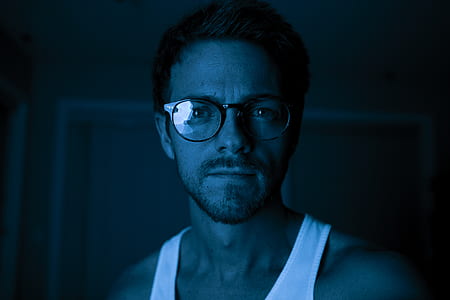man wearing eyeglasses inside dark room thumbnail