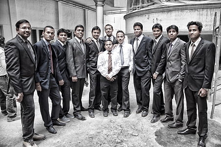 men wearing formal suits standing side by side thumbnail