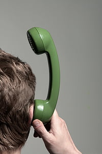 man holding green telephone headset near his ears thumbnail