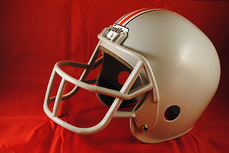 gray and red football helmet on red textile thumbnail