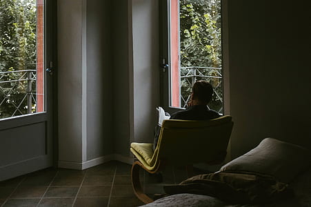 man sitting on chair in front of door inside room at daytime thumbnail