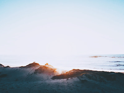 silhouette of sand near body of water thumbnail