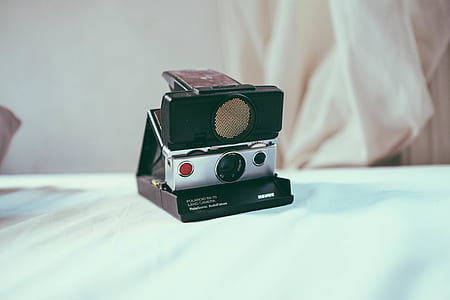 black and gray instant camera on white textile thumbnail