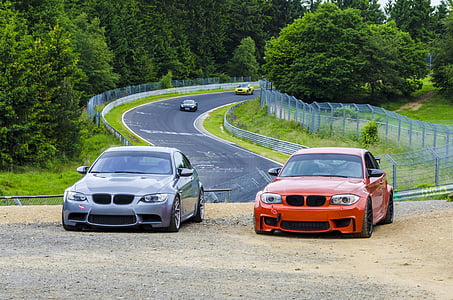 two gray and red BMW cars parkes near on raod thumbnail