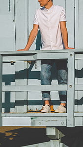 man leaning on blue wooden rail thumbnail