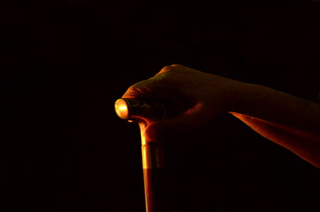 Hand leans on walking stick thumbnail