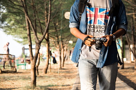 Man Holding Dslr Camera While Walking thumbnail