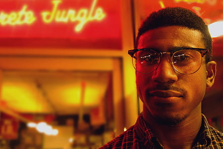selective focus photography of person standing near lighted signage thumbnail