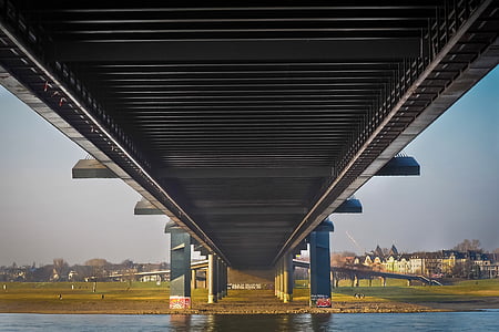 gray concrete bridge over body of water during daytime thumbnail