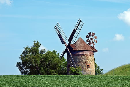 Brown and Gray Windmill Beside Green Tree Under Blue Cloudy Sky during Day Time thumbnail