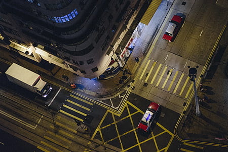 aerial photography of two red vehicle on road beside building during nighttime thumbnail
