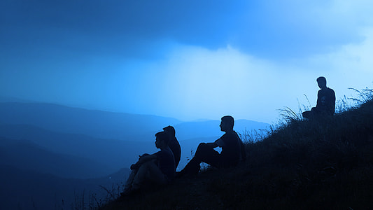 four men sitting on hill thumbnail