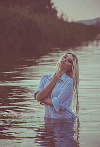 woman wearing blue shirt on water during daytime thumbnail