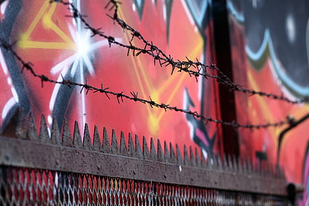 barbed wire against red wall thumbnail