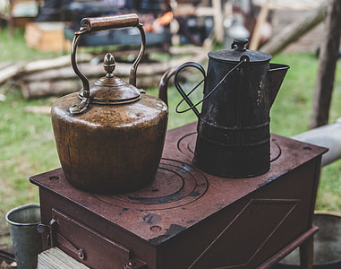two brown and black kettle on brown metal table thumbnail