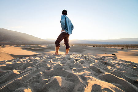 person standing on sand with hands on hips thumbnail