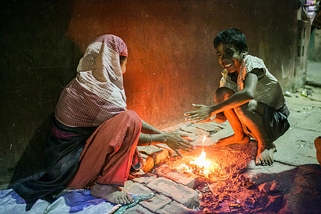 woman and boy sitting in front of bonfire thumbnail