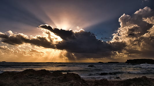 Body of Water Under Clouds With Sun Rays thumbnail
