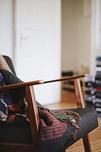 shallow focus photography of black leather padded rocking chair with brown wooden frame thumbnail