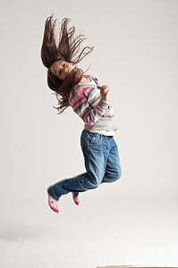 photo of jumping girl in sweater and blue denim jeans thumbnail