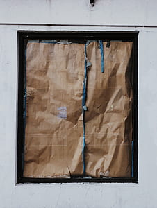 window covered by brown paper thumbnail