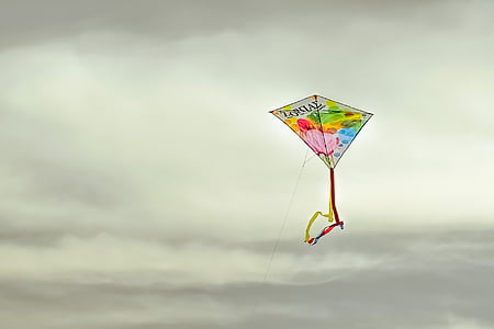 multicolored kite under gray cloudy sky thumbnail