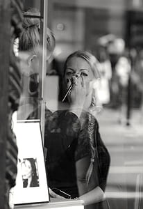 grayscale photography of woman putting makeup on another woman thumbnail