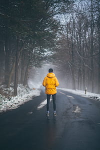 man wearing yellow jacket standing on road thumbnail