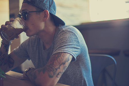man in grey crew-neck shirt drinking thumbnail
