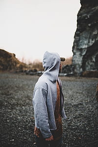man wearing hoodie and facing on rock thumbnail