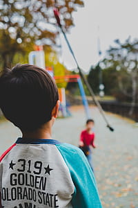child standing in front of child near playground thumbnail