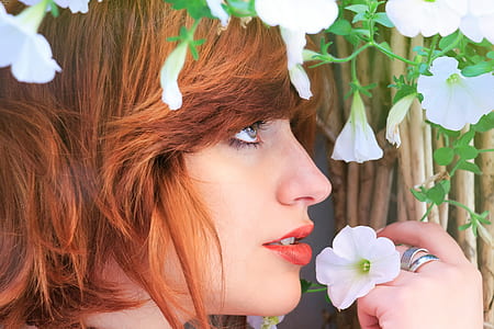 woman holding white petaled flower thumbnail