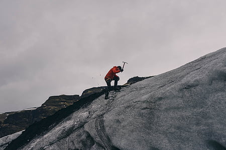 man holding pickaxe on gray rock thumbnail