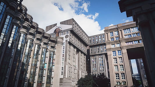 brown high-rise building under cloudy sky thumbnail