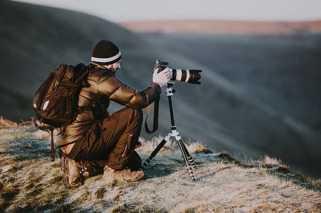 man at cliff taking photo of the view during daytime thumbnail