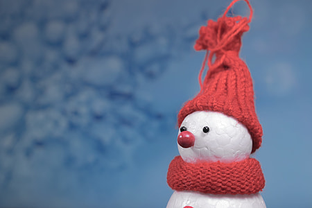 selective focus photography of snowman wearing red knitted hat and scarf thumbnail