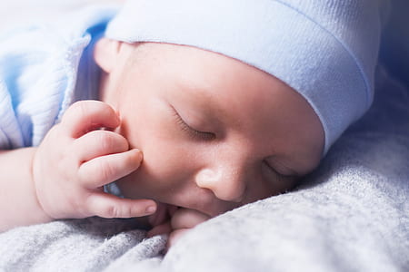 baby sleeping wearing white beanie hat thumbnail