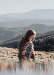 shallow focus photography of woman in black, red, and white pinstripe coat thumbnail