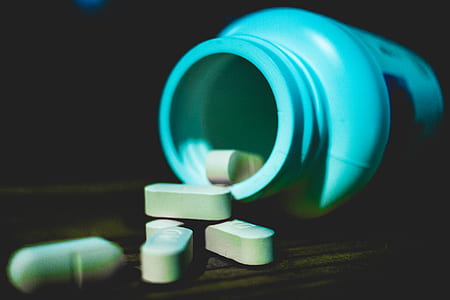 medication tablets near plastic container thumbnail