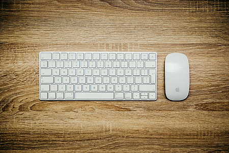 Apple Wireless Keyboard and Magic Mouse on wooden panel thumbnail