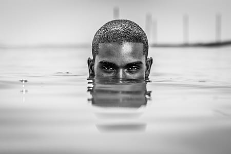 macro photography of half-face of man's head underwater thumbnail