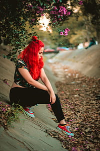 Woman Wearing Multicolored Cap-sleeved Crop Top and Black Pants on Concrete Pavement Under Purple Bougainvillea Flowers thumbnail